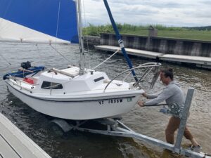 Bill Burrell loads his sailboat into Lake Champlain
